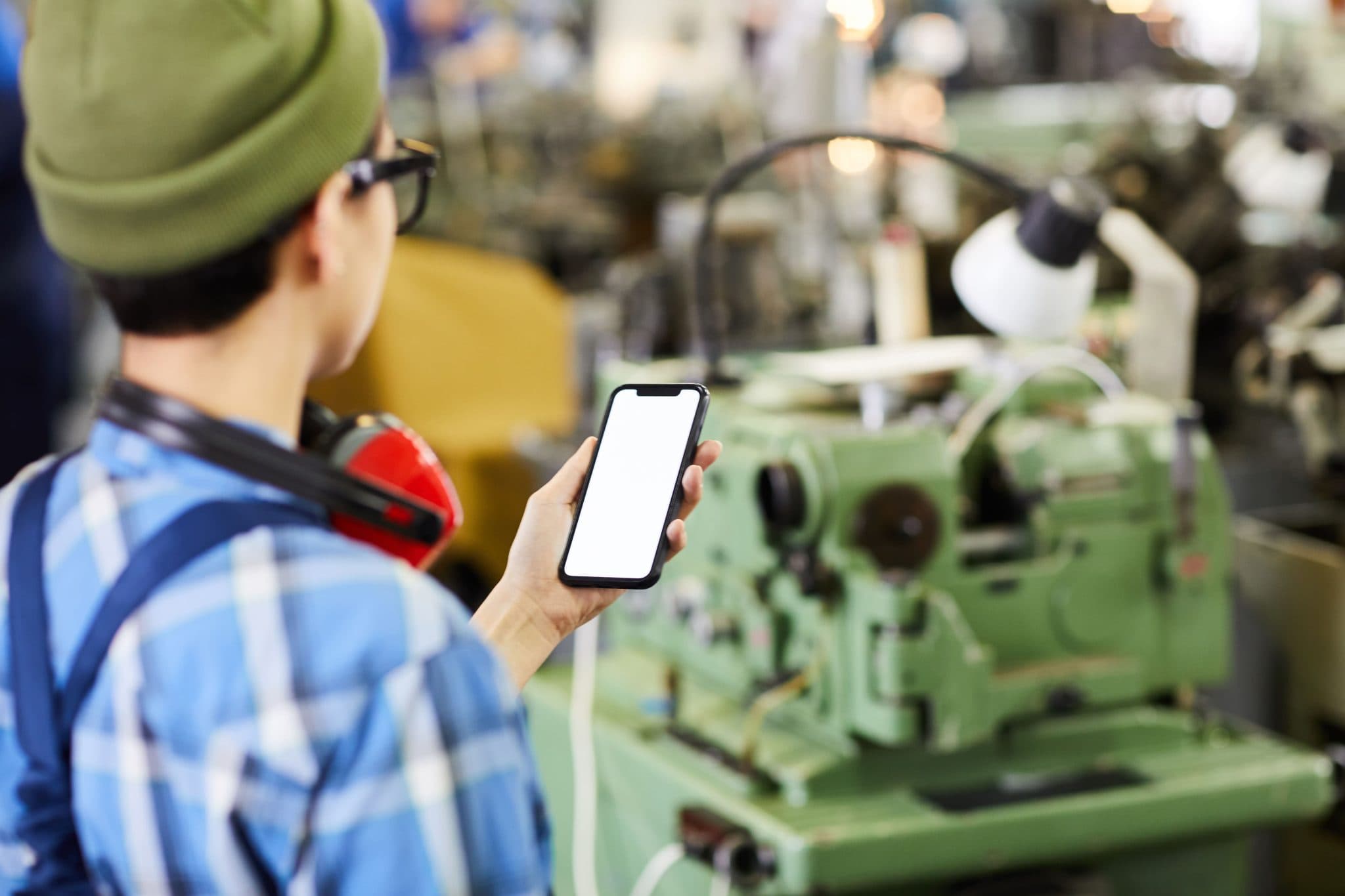AI detecting a worker using their smartphone while walking through a warehouse, with overlay showing distracted walking alert
